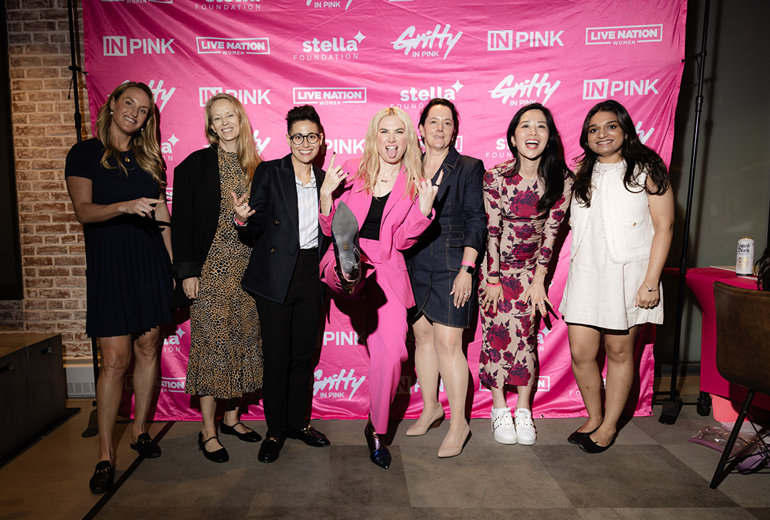 GrittyInPink group in front of step repeat banner